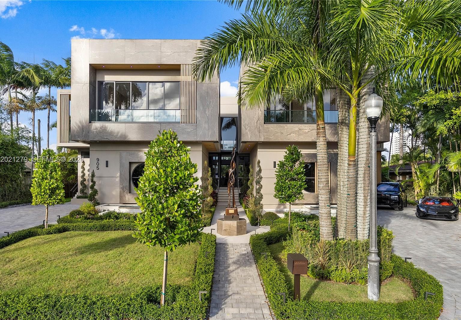 Daylight street elevation showing the symmetry of the two-story limestone volume and the central entry axis
