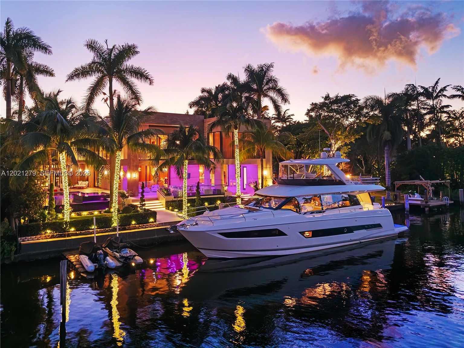 Villa Miradar from the open bay, the yacht slip in the foreground and the pool deck reading as one continuous line with Biscayne